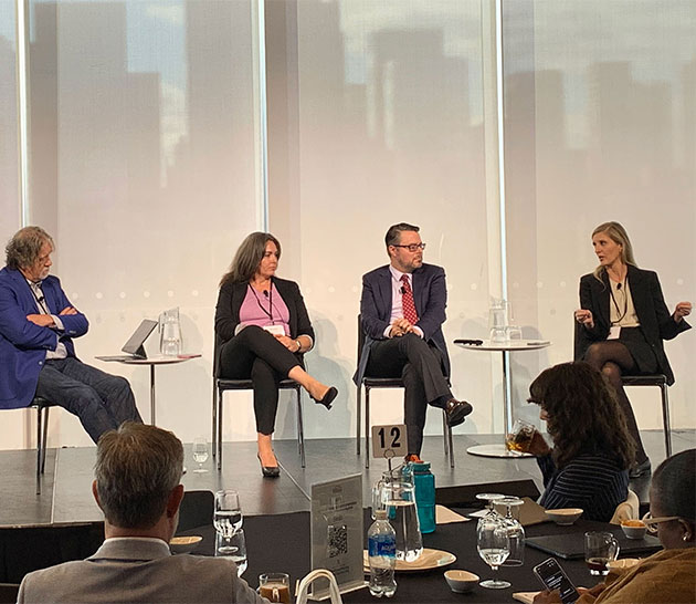 Three panelists and a moderator speaking to each other